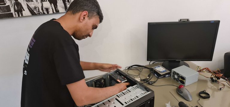 משה הטכנאי מתקן מחשב נייח מפורק על השולחן